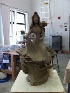 A work in progress, Sculpture of the goddess quan yin out of grey clay. this image: front view