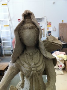 A work in progress, Sculpture of the goddess quan yin out of grey clay. this image: front close up