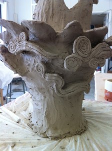A work in progress, Sculpture of the goddess quan yin out of grey clay. this image: base focusing on clouds before the dragon or striations are added.